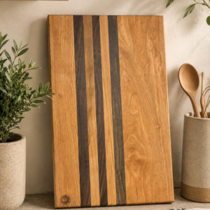 Long striped rectangular Cherry, Walnut, and maple cutting board in kitchen setting.